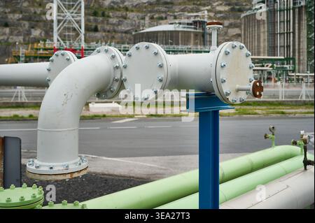 Industrial pipes and pipelines forming a complex grid, transporting fluids and gases in a petroleum refinery or chemical plant Stock Photo