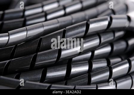 Macro shot focusing on glossy texture and overlapping layers black spiral cable protector Stock Photo