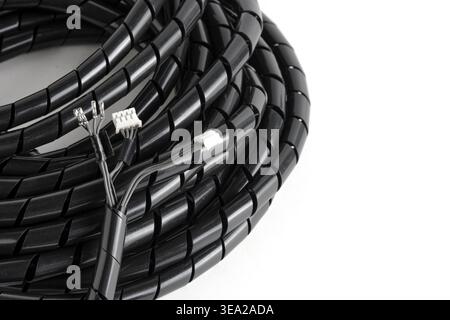 Black spiral wrap with electronic wires and white plastic connectors protruding from end Stock Photo