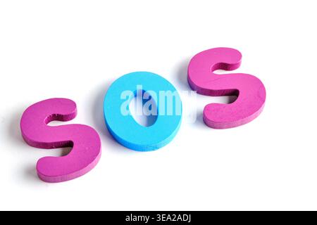 Word SOS spelled out using colorful, toy like wooden letters on plain white background Stock Photo