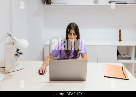 Female optometrist working on laptop in medical office Stock Photo