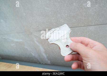 Grouting ceramic tiles using a fugue. Worker putting fugue on tiles closeup. tiles renovation Stock Photo