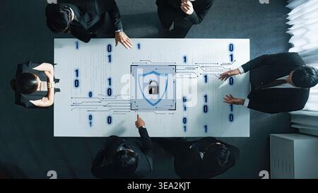 A business team collaborates on cybersecurity strategy, focusing on a digital lock design on the table surrounded by binary code, emphasizing data Stock Photo