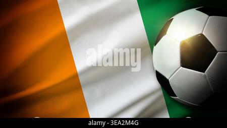 A soccer ball rests on the Ivory Coast flag, showing orange, white, and green vertical stripes with soft lighting and shadows, symbolizing football an Stock Photo