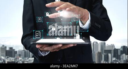 Businessman in Suit Interacting with Virtual Security Interface on Tablet Over Cityscape Background for Cybersecurity and Technology Concepts Quark. Stock Photo