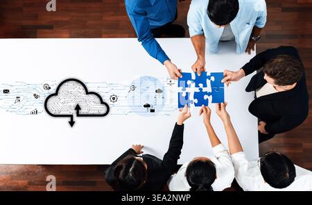 A diverse group of professionals collaborates on a cloud technology project, assembling a puzzle symbolizing innovative problem-solving and teamwork Stock Photo