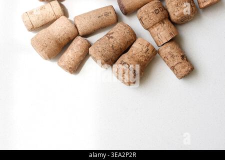 Top view of several wine corks placed on a clean white table. Minimalist composition highlighting natural texture, warm tones, and simple arrangement. Stock Photo