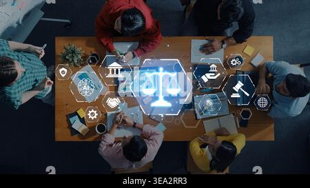 A diverse group of professionals collaborates in a modern workspace, utilizing digital tools and symbols of justice, law, and innovation for effective Stock Photo