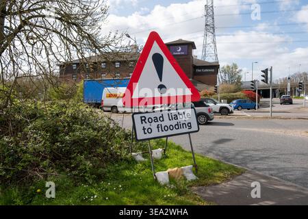Road liable to flooding triangular exclamation sign at the junction of the slip road on the M3/M27 leading from Leigh Road Eastleigh near junction 13. Stock Photo