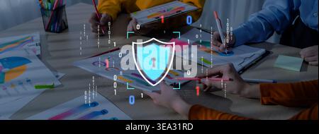 A diverse group of professionals collaborates on cybersecurity strategies in a modern office setting, using vibrant charts and visual elements to Stock Photo