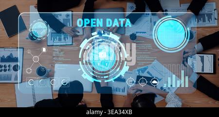 A group of professionals collaborates on open data strategies, surrounded by graphs and digital interfaces that represent analysis and data protection Stock Photo