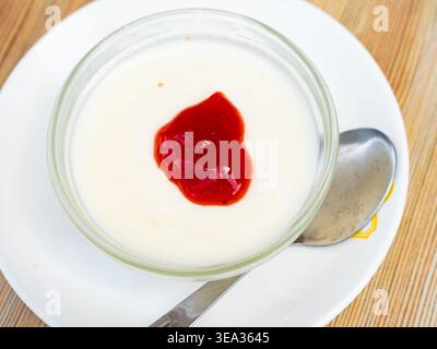 Creamy panna cotta with cranberry jam in glass bowl Stock Photo