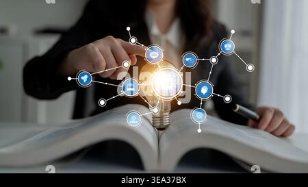 A business professional engages with a light bulb and digital icons, symbolizing innovative ideas and strategies in a modern workplace focused on Stock Photo
