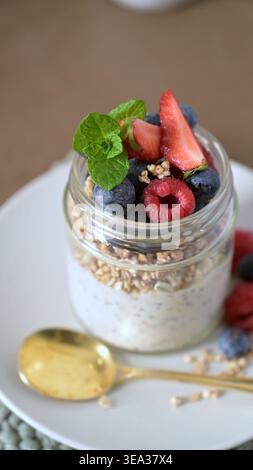 Creamy oatmeal topped with fresh raspberries mint leaves in ribbed ...