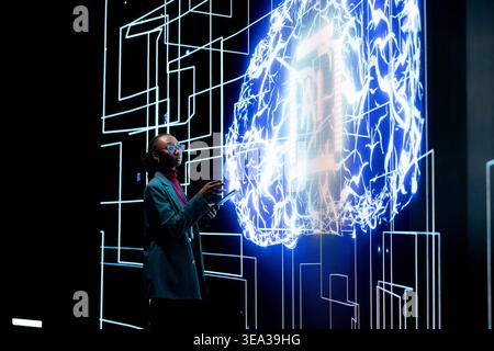 Female engineer reports to automated artificial intelligence supervisor on dashboard. African american woman completes assignments distributed by AI agent, future of workforce concept Stock Photo