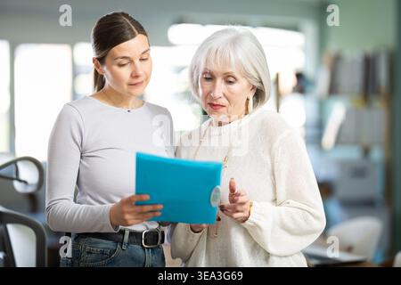 Woman shows elderly colleague documents Stock Photo