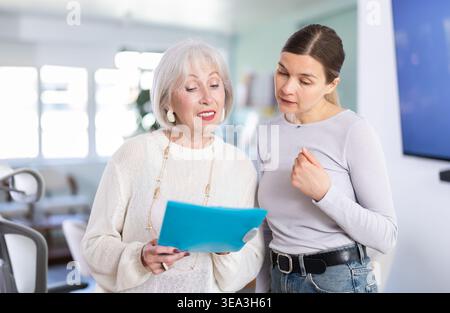 Woman shows elderly colleague documents Stock Photo