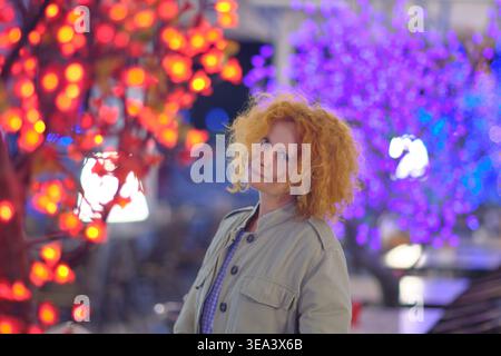 Portrait of a woman in artistic neon lighting on a night city street Stock Photo