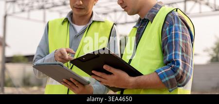 Engineers team use checklist and check the blueprint on site. Contractor and inspector inspection construction during project.civil Forman check quali Stock Photo