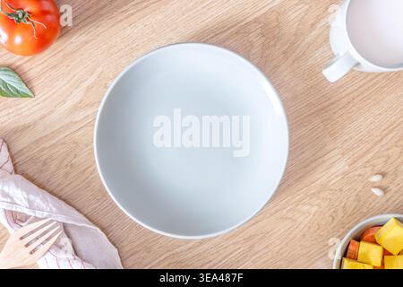 A close-up of an empty light green plate on a wooden table for breakfast. Concept of eating a balanced diet. Top view. Flat lay. Stock Photo