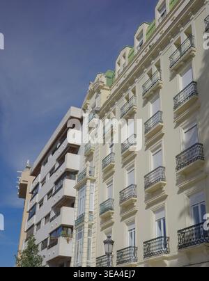 Classical cream facade with ornate wrought iron balconies contrasting with a modern apartment building on Gran Vía de Colón, Granada, Andalusia, Spain Stock Photo