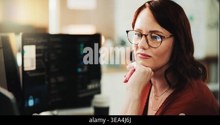 Computer, programmer and thinking with woman in office for coding, cyber security or cloud computing. Programming, research and developer with person Stock Photo
