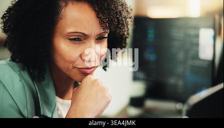 Computer, coding and thinking with woman in office for programmer, cyber security or cloud computing. Programming, reading and developer with person Stock Photo