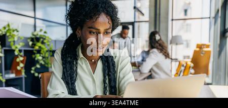 Woman focused on analyzing digital marketing data in office environment Stock Photo