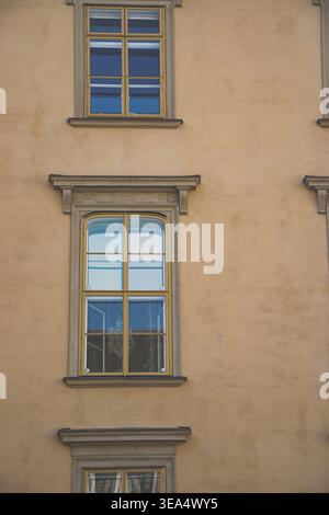 Historic building facade with symmetrical windows and decorative stone frames in Vienna, showing architectural detail and urban exterior wall Stock Photo