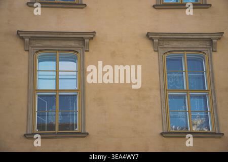 Historic building facade with two symmetrical windows and decorative stone frames in Vienna, exterior wall detail and urban architectural design Stock Photo