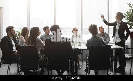 Boss talking to employees, having brainstorm meeting in office Stock Photo