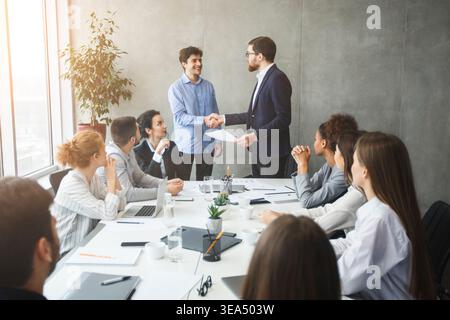 CEO congratulating successful worker by shaking hands Stock Photo
