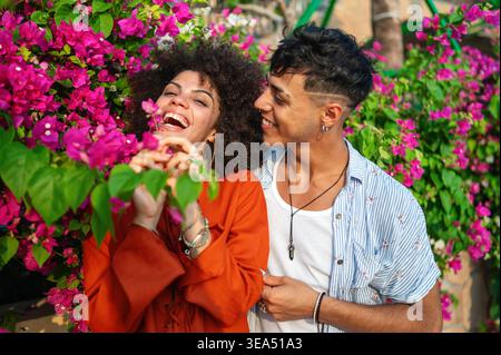 A multicultural couple enjoys a moment of love and connection in a beautiful blooming summer garden Stock Photo