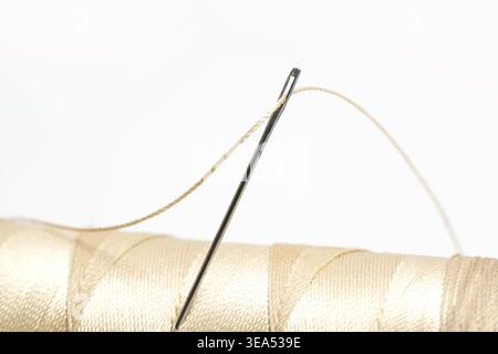 Close-Up of Thread and Sewing Needle on White Background, Minimal Tailoring and Craft Concept Stock Photo