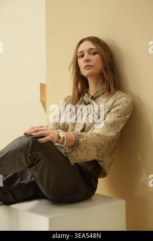Studio Fashion Portrait of Woman in Green Paisley Silk Tie Neck Blouse with Dark Brown Leather Pants Stock Photo