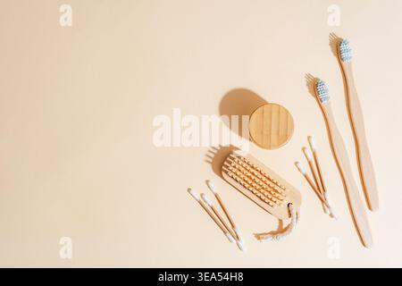 Natural bamboo toothbrushes and eco friendly hygiene accessories on beige background with sunlight shadows. Minimalist flat lay composition. Top view, Stock Photo