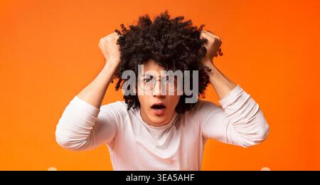 Emotional black guy shouting and rending his hair in stress Stock Photo
