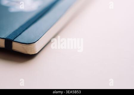 Blue notebook corner on soft beige background with copy space Stock Photo