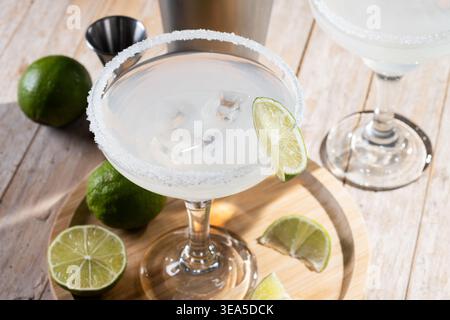 Classic margarita cocktail with lime and salt rim on wooden table Stock Photo