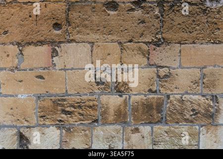Rough stone wall texture with beige masonry blocks for background Stock Photo