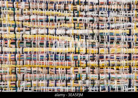 Top view of handmade woven rug made of thick yarn on wooden surface. Rustic folk textile background with copy space. Stock Photo