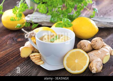 Lemon tea with ginger slices, seasoned with basil and parsley Stock Photo