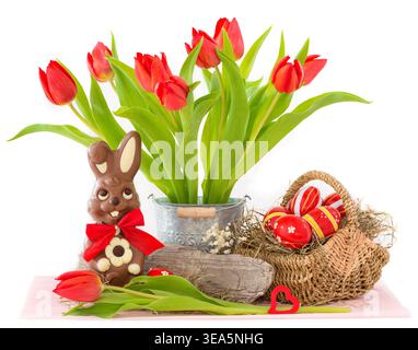 Bouquet of red tulips in a metal bucket with an Easter basket, Easter bunny, and Easter eggs, composite image, cutout Stock Photo