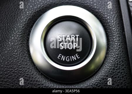 Extreme close up of a modern car start stop engine ignition button with silver metallic trim Stock Photo