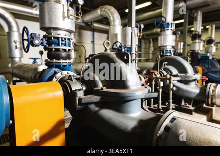 A skilled worker uses tools to repair a large industrial pump, highlighting mechanical engineering and factory operations Stock Photo