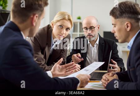 Business team discussing strategy in modern office, reviewing reports and planning Stock Photo