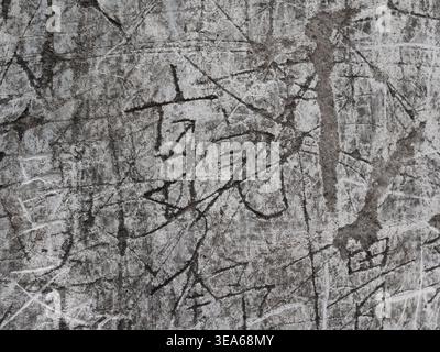 Aged concrete wall showing deep scratches and various carved characters creating an abstract pattern Stock Photo