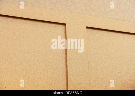 Katara Cultural Village, Doha, Qatar - December 23, 2025: A close-up shot of the golden-textured wall at the Golden Mosque in Katara. Stock Photo