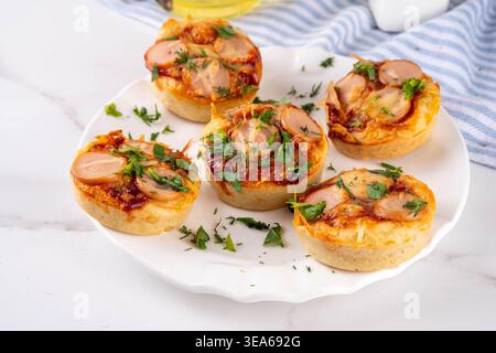 Chicago style pizza bites, Portioned Deep Dish Pizza Cupcakes, pizza muffins with tomato sauce, a lot of cheese, ham sausages Stock Photo