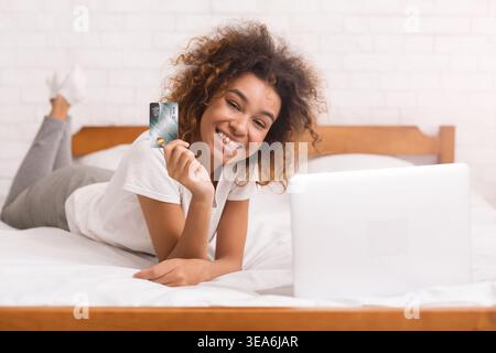 African-american woman doing online shopping in the bedroom Stock Photo